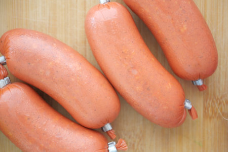 Freshly Packaged Sausages Arranged Beautifully on a Wooden Surfaceの写真素材