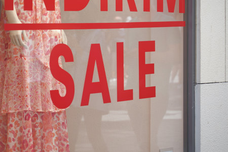 Large red Sale text letters on a glass wall obstruct a view inside the popular fashion storeの写真素材