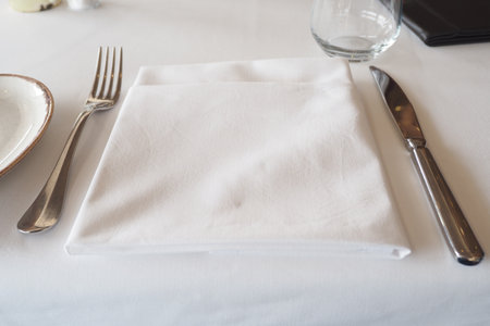 An Elegant Table Setting Featuring a White Napkin Alongside Cutleryの写真素材