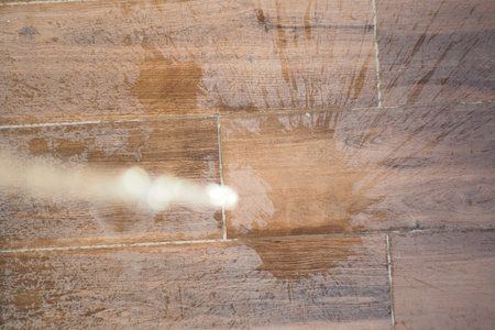 Water stains on the wooden tile floor need cleaning spray for removalの写真素材