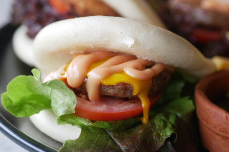 A truly delicious Bao Burger garnished with fresh Tomato and crisp Lettuceの写真素材