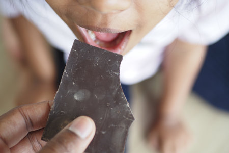 child eating dark chocolate close upの写真素材