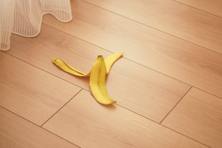 A Wilted Banana on a Wooden Floor Surrounded by White Fabric, Emphasizing the Contrastの写真素材