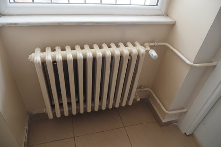 White radiator on grey white wall. apartment heating installation system,の写真素材