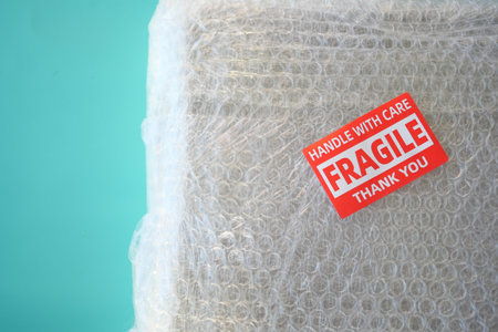 A cardboard box marked with a caution label for fragile goods handling during shippingの写真素材