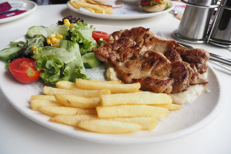 Delicious Grilled Chicken served with Crispy Fries and a Fresh Saladの写真素材
