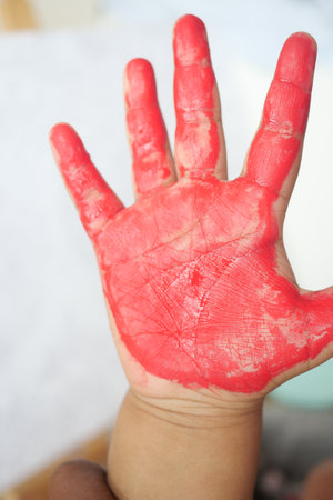 A Bright and Vibrant Red Painted Handprint Made by a Creative Childの写真素材