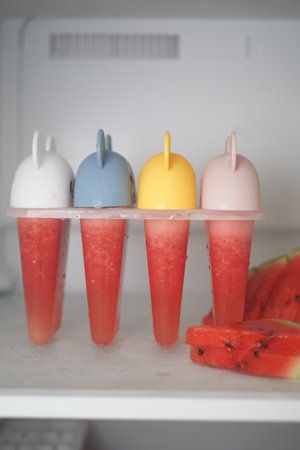 Colorful Homemade Popsicles in Freezer with Watermelon Slicesの写真素材