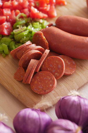 An array of fresh vegetables and sliced sausages has been beautifully laid out for cookingの写真素材