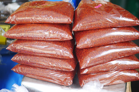 Piles of Spicy Chili Powder Organized in Clearly Labeled Bags for Saleの写真素材