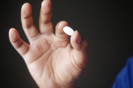 Close-Up of Hand Holding Small Vitamin or Medicine Tabletの写真素材