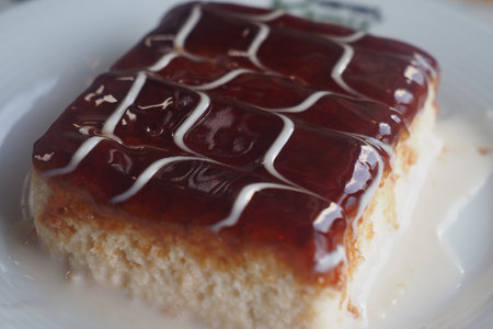 Delicious layered cake with fruit glaze and cream drizzle for dessertの写真素材