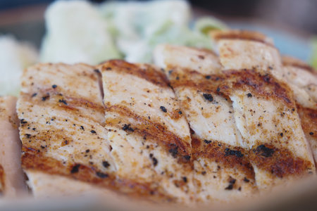 Delicious Grilled Chicken Breast Served with Expertly Seasoned Cuts on the Plateの写真素材