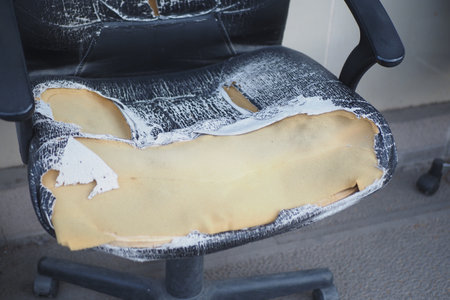 A WornOut Office Chair that has Exposed Foam and is in poor conditionの写真素材