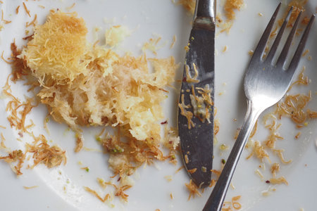 An empty plate with a spoon rests after a meal has been enjoyedの写真素材