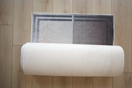 Beautifully designed Elegant Rolled Area Rug placed on a Wooden Floorの写真素材