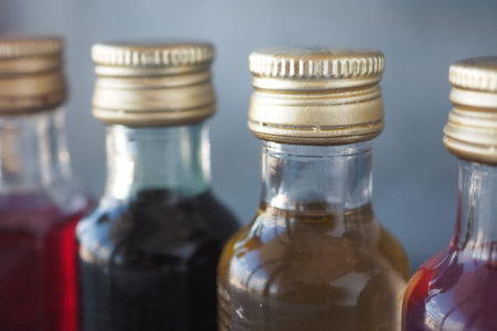 Vibrantly Colorful Bottles of Syrups Featuring Elegant Golden Capsの写真素材