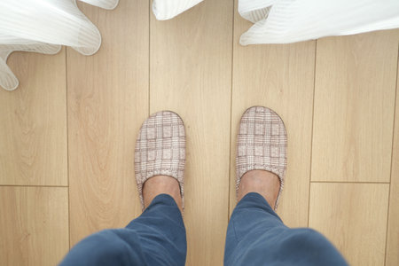 Comfortable Cozy Indoor Slippers Resting on a Wooden Floor Surfaceの写真素材