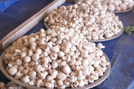 Fresh White Mushrooms Displayed in Bowls at Local Market for Saleの写真素材