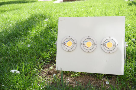 An Outdoor Spotlight Fixture placed on a lush Green Grass area showcasing intense illuminationの写真素材