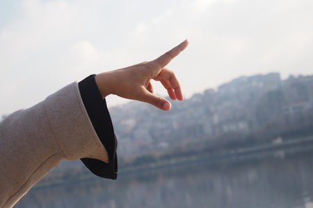 An Elegant Gesture Captured Against a Scenic Urban City Backdropの写真素材