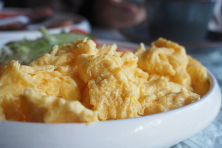 Close-Up of Creamy Scrambled Eggs in a Ceramic Serving Bowlの写真素材