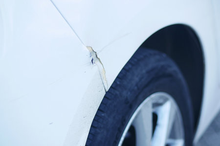 A detailed closeup image showcasing the damaged fender and tire of a carの写真素材