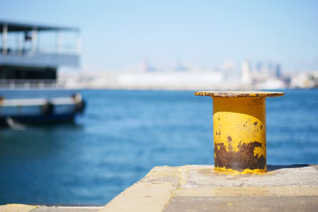 A striking Yellow Mooring Post stands proudly by the Waters Edgeの写真素材
