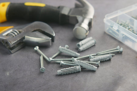 A collection of assorted hand tools and screws laid out on a work surface