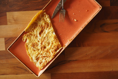 A beautiful Golden Brown Omelette served elegantly on a Plate with a Forkの写真素材