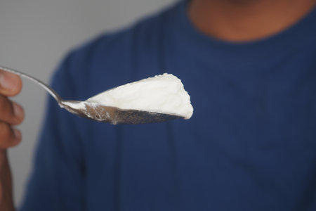A Spoonful of Creamy Yogurt Delicately Balanced in My Hand for Enjoymentの写真素材