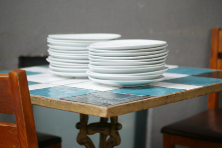 Neatly arranged stacked plates displayed beautifully on a colorful tabletopの写真素材