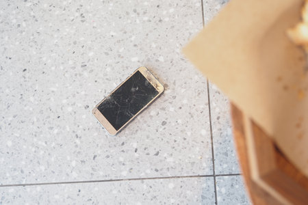 Top view of broken smart phone on tiles floorの写真素材
