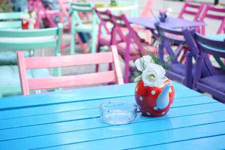 A Colorful Cafe Table Adorned with Beautiful Flowers and Vintage Decorの写真素材