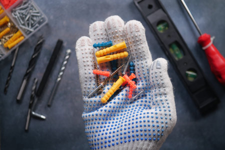 A Hand Holding Tools and Fasteners for Various Home Improvement Projectsの写真素材