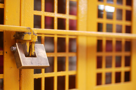 CloseUp Focus on a Yellow Locked Gate Featuring a Gridded Design Patternの写真素材
