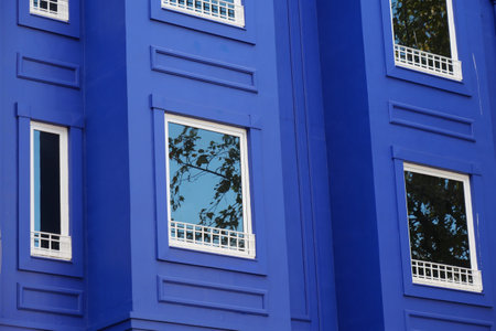 A Vibrant Blue Building Featuring Reflective Windows and Modern Balconiesの写真素材