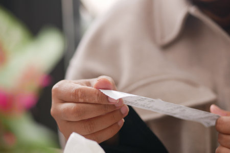 closeup woman hand holding a of Sales receipts on table ,の写真素材