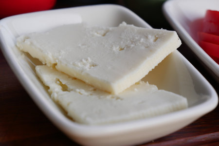 Delicious Soft Cheese Blocks Arranged on a Plate with Fresh Garnishの写真素材