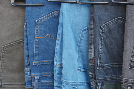 A collection of assorted denim jeans displayed neatly on hangersの写真素材