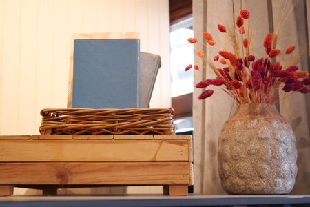 Cozy reading nook with a wooden bookshelf, books, and orange flowers, perfect for literature loversの写真素材