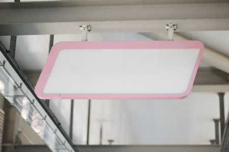 Hanging Pink Blank Sign Set Against a Stylish Industrial Backgroundの写真素材