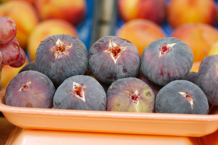 Fresh, ripe figs are beautifully displayed at a bustling farmers market