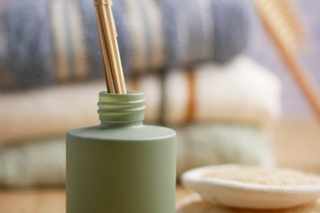 Green Aroma Diffuser and Natural Spa Essentials on a Wooden Tableの写真素材