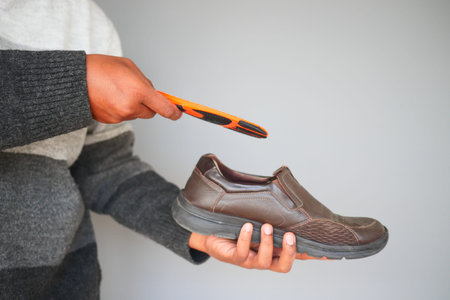 man hand putting Orthopedic insoles in shoesの写真素材