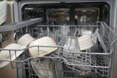 The Dishwasher is Fully Loaded with Sparkling Clean Dishes and Bowls Nowの写真素材