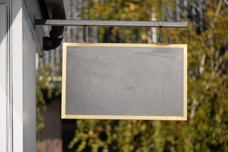 An empty chalkboard sign is currently hanging outside, awaiting messagesの写真素材
