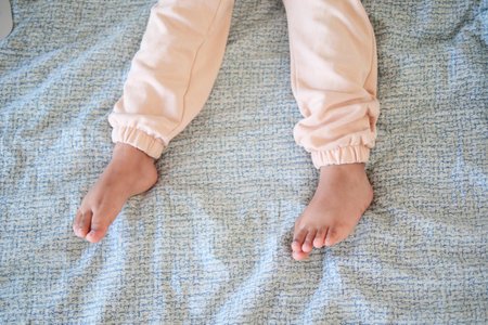 A Childs Cozy Little Feet Relaxing Comfortably on a Soft Blanketの写真素材