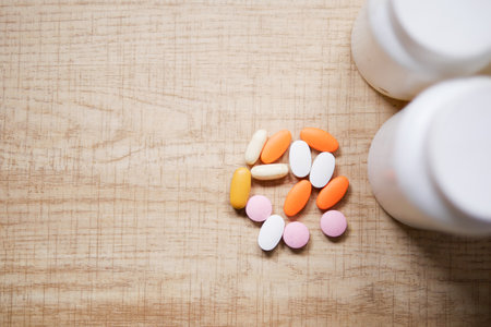 A Variety of Assorted Vitamins and Medications Displayed on a Wooden Surfaceの写真素材
