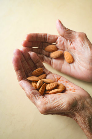 almond nuts on senior women handの写真素材